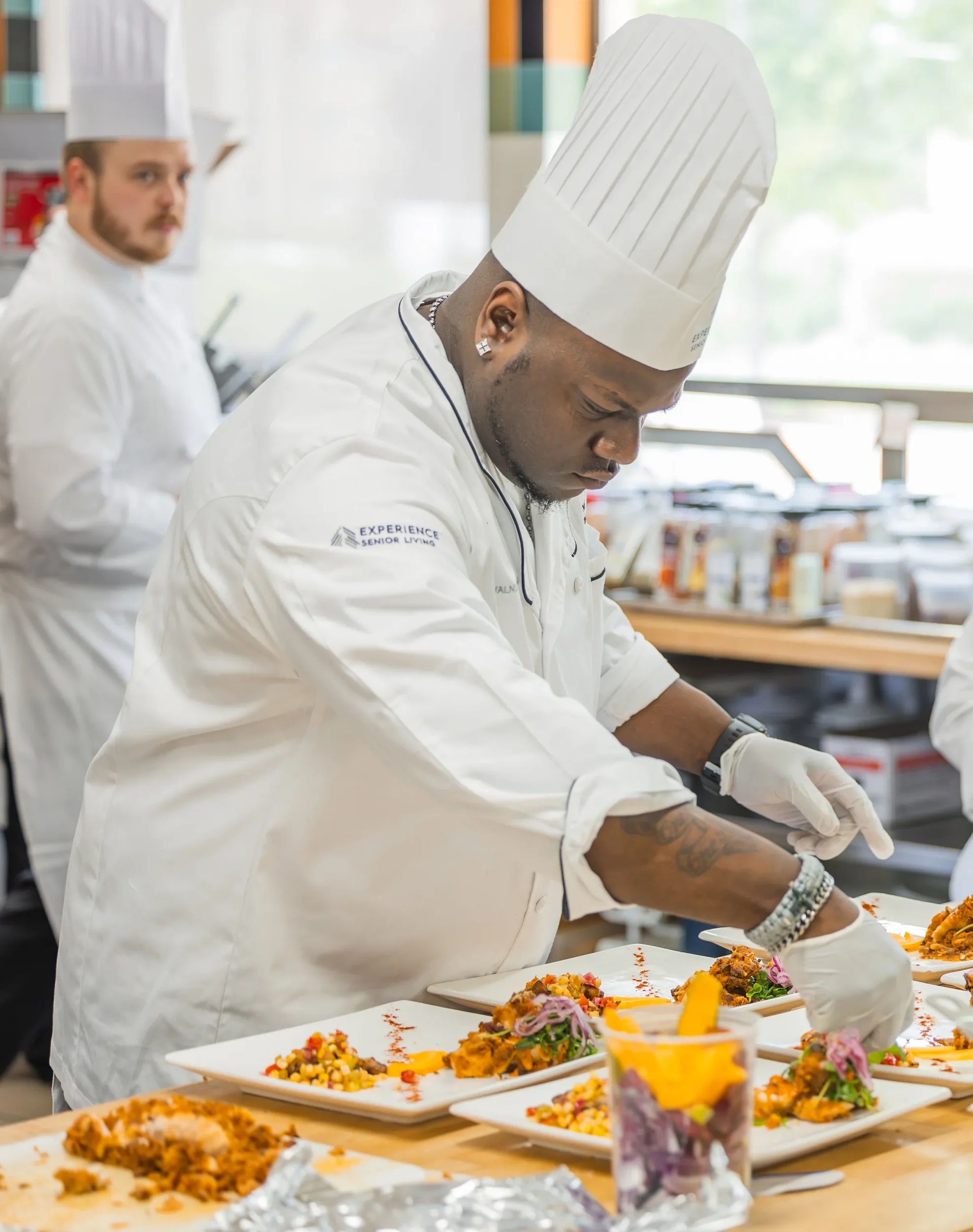 chef plating food in kitchen at senior living community