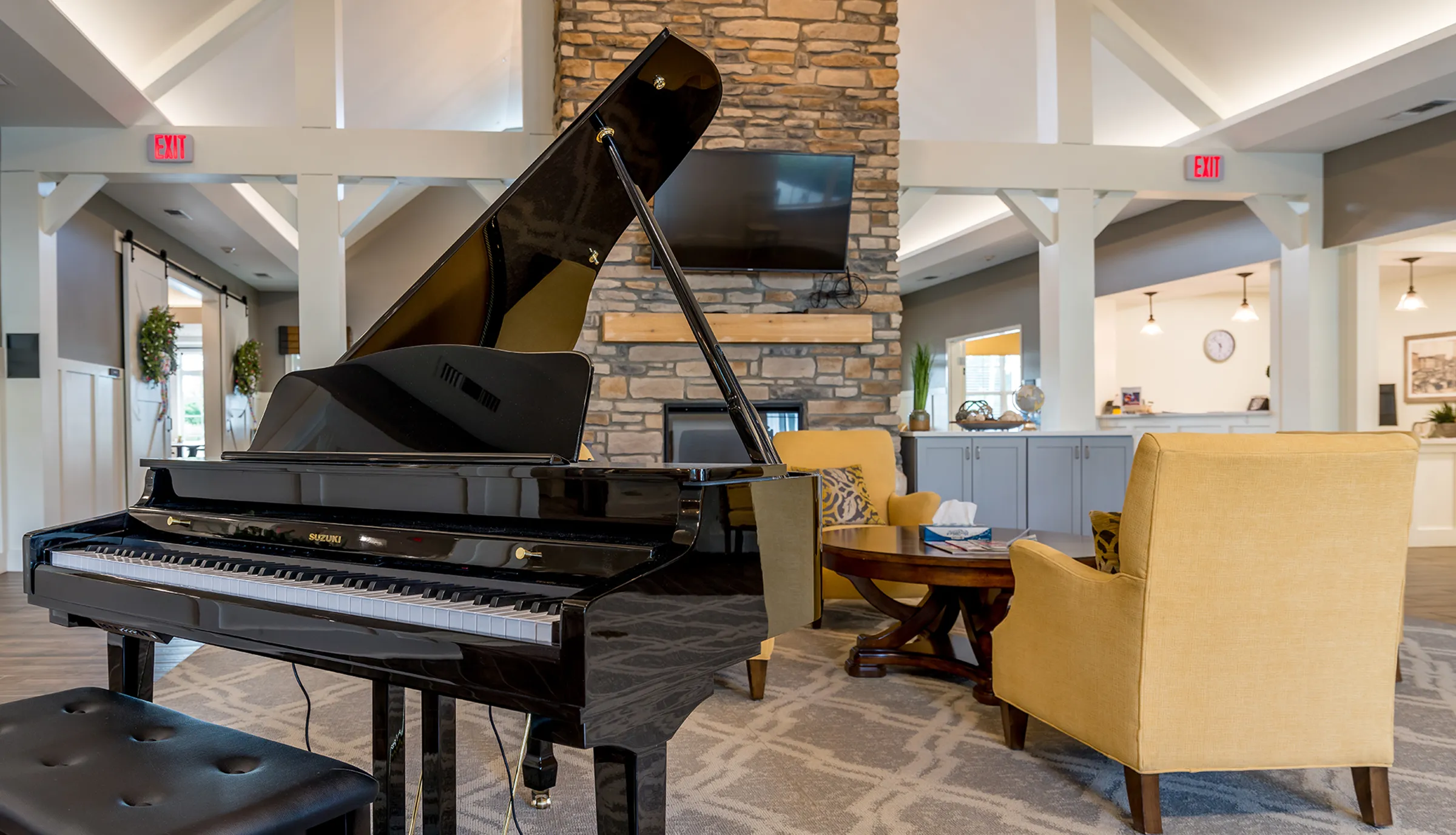 grand piano in living room with fireplace in senior living community