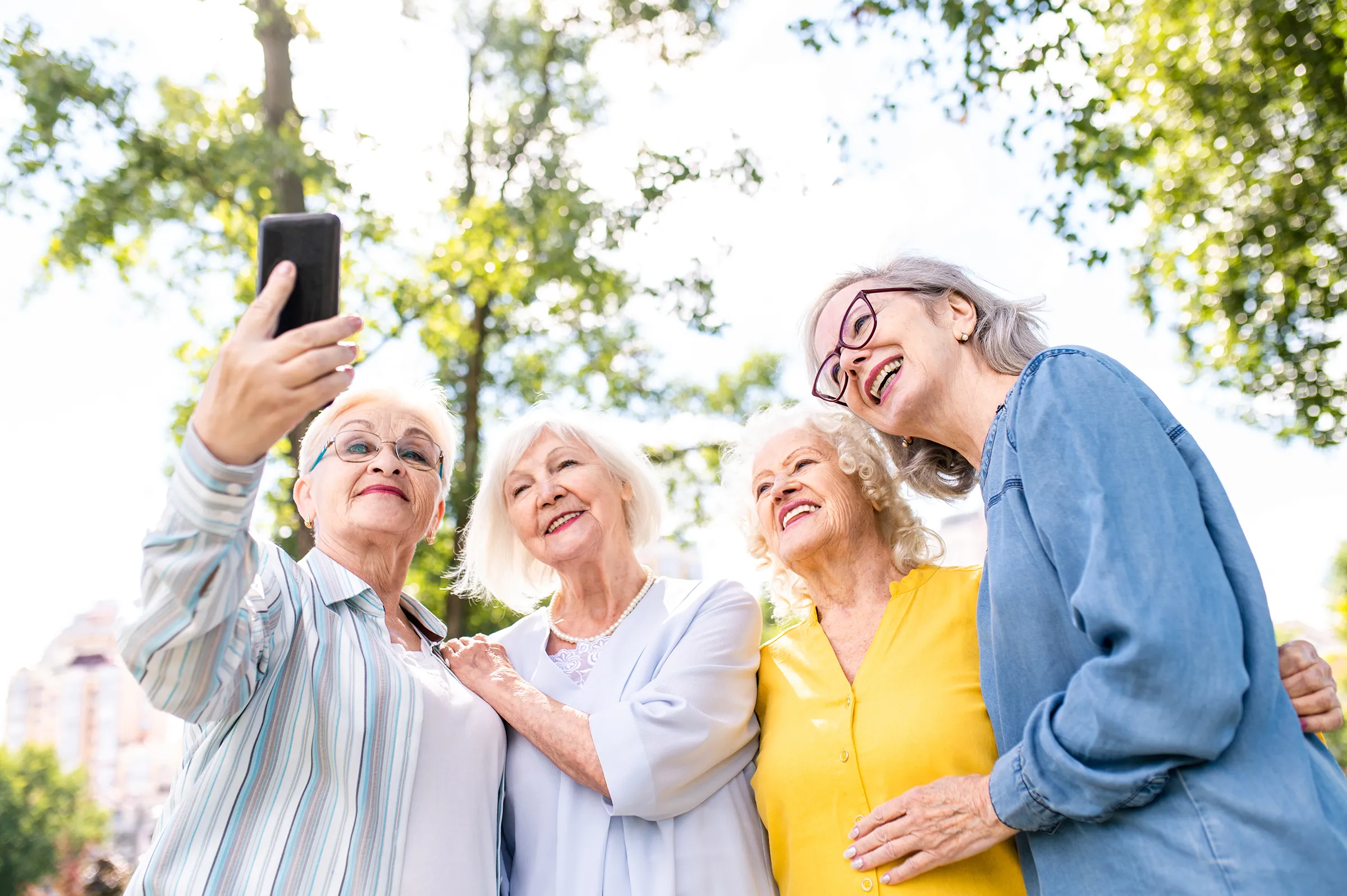 group of women smiling taking a selfie outside