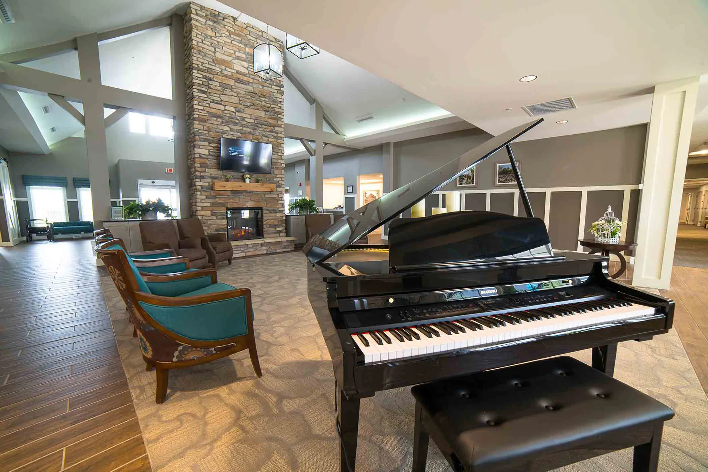 senior living community lobby with grand piano and floor to ceiling fireplace