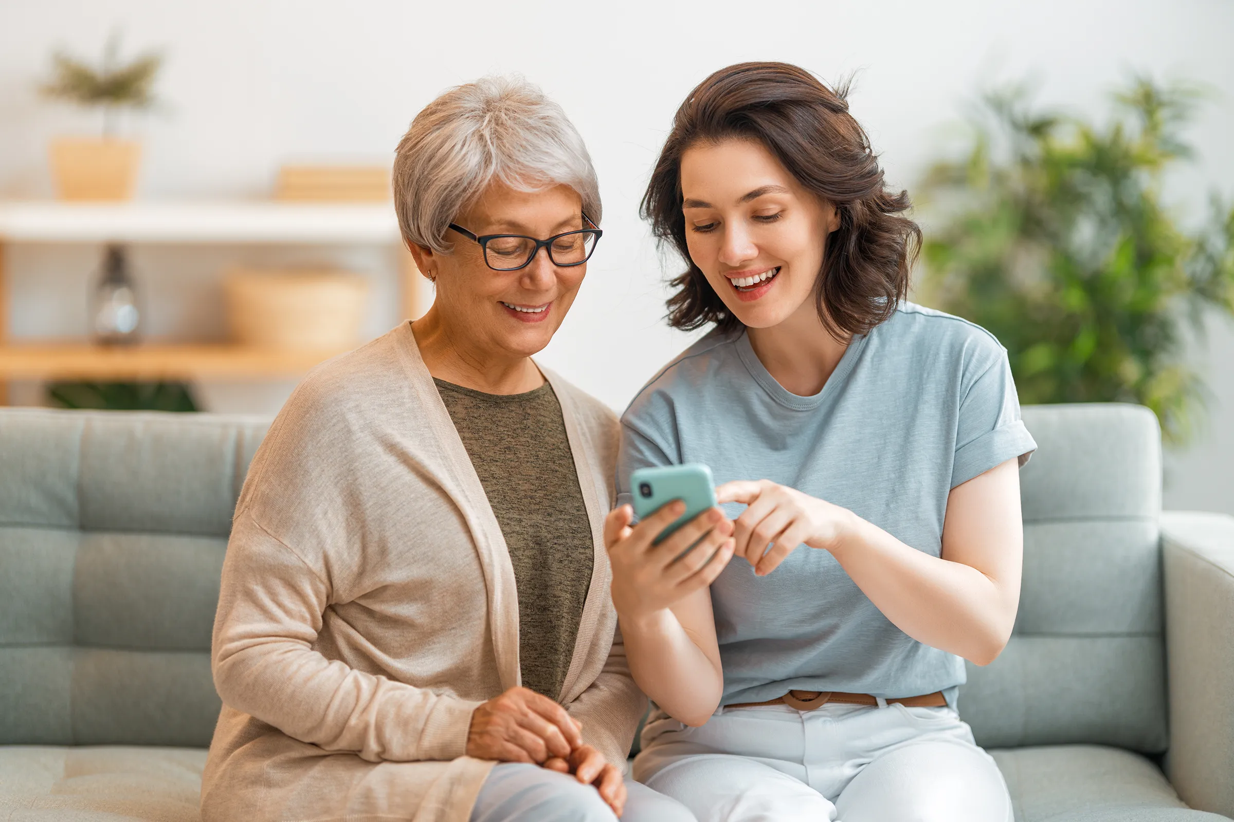 younger woman showing older woman something on her phone