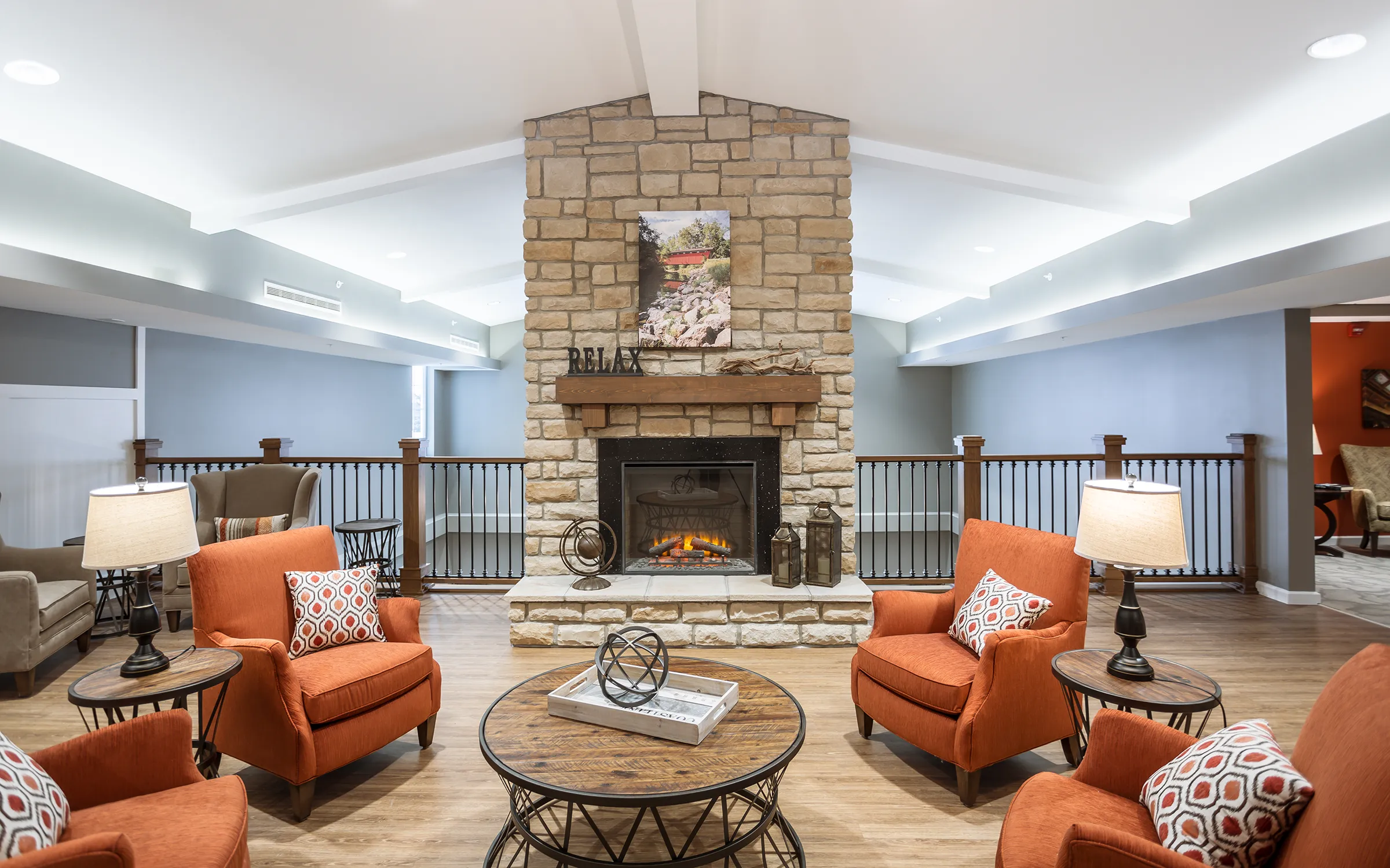 second floor living room with fireplace and chairs in senior living facility