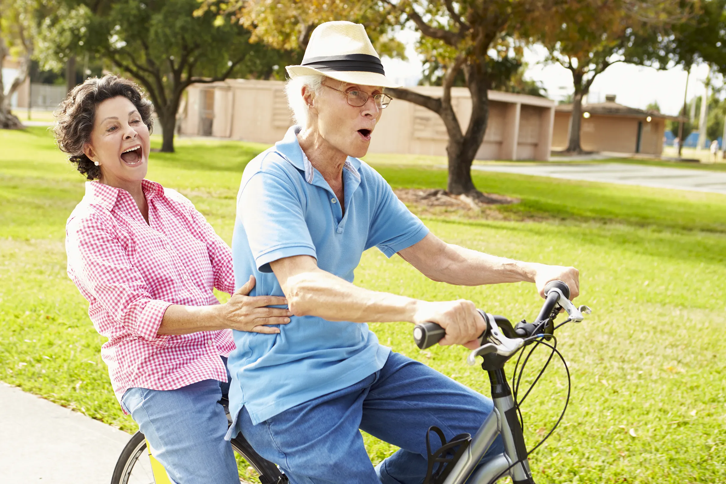 man and woman laughing on bike outside