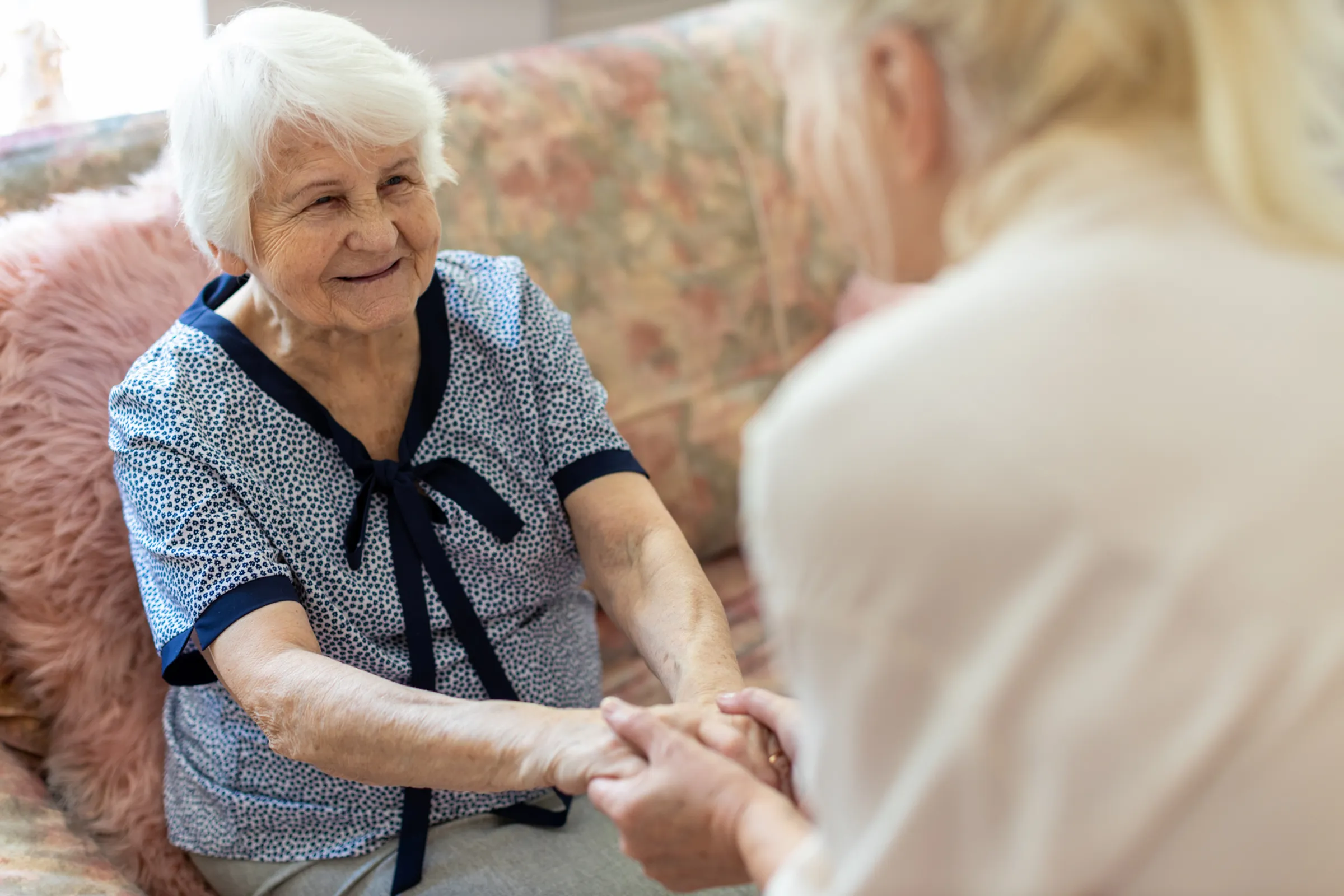 smiling woman on couch in assisted living community