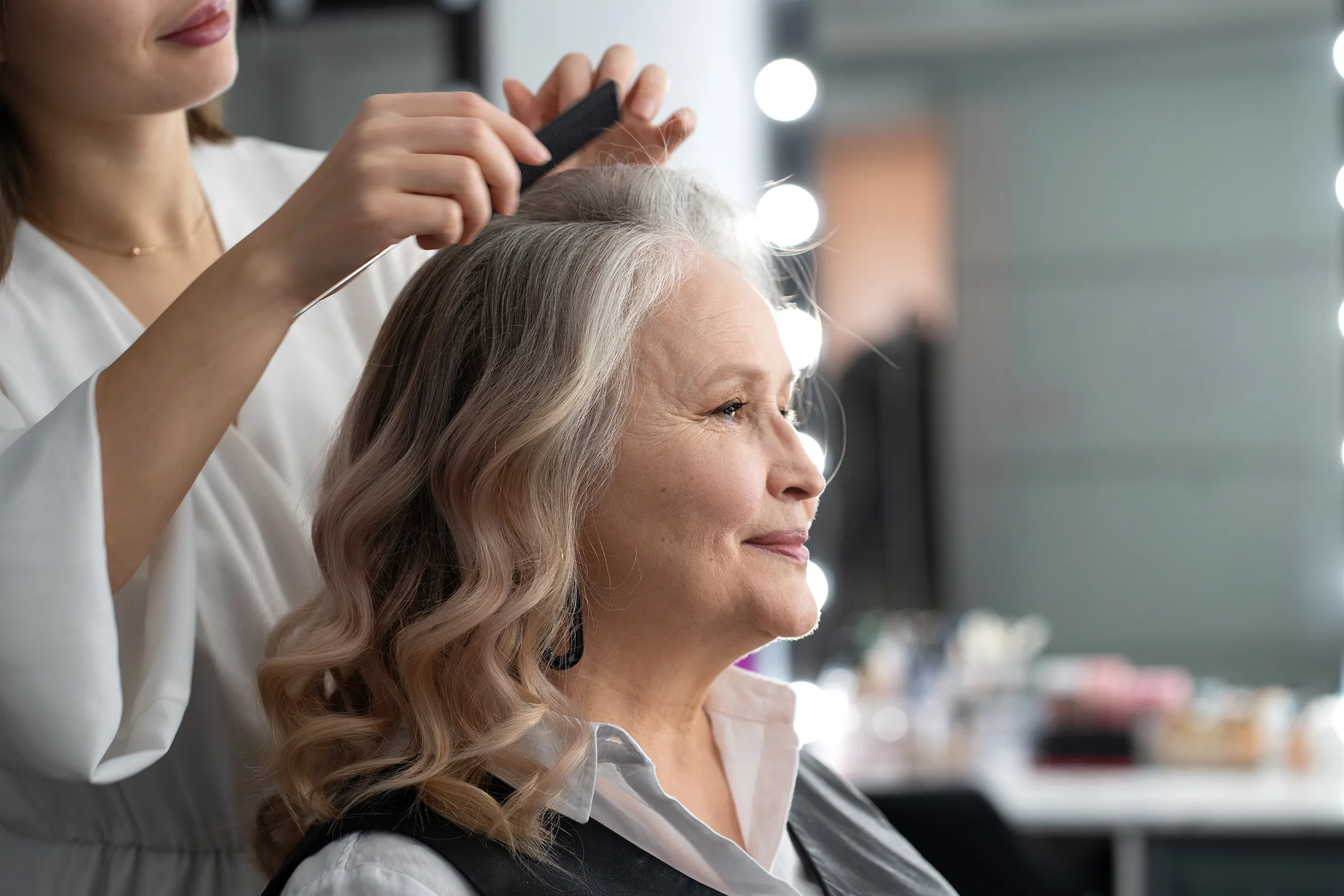 older woman getting her hair styled at salon in senior living community