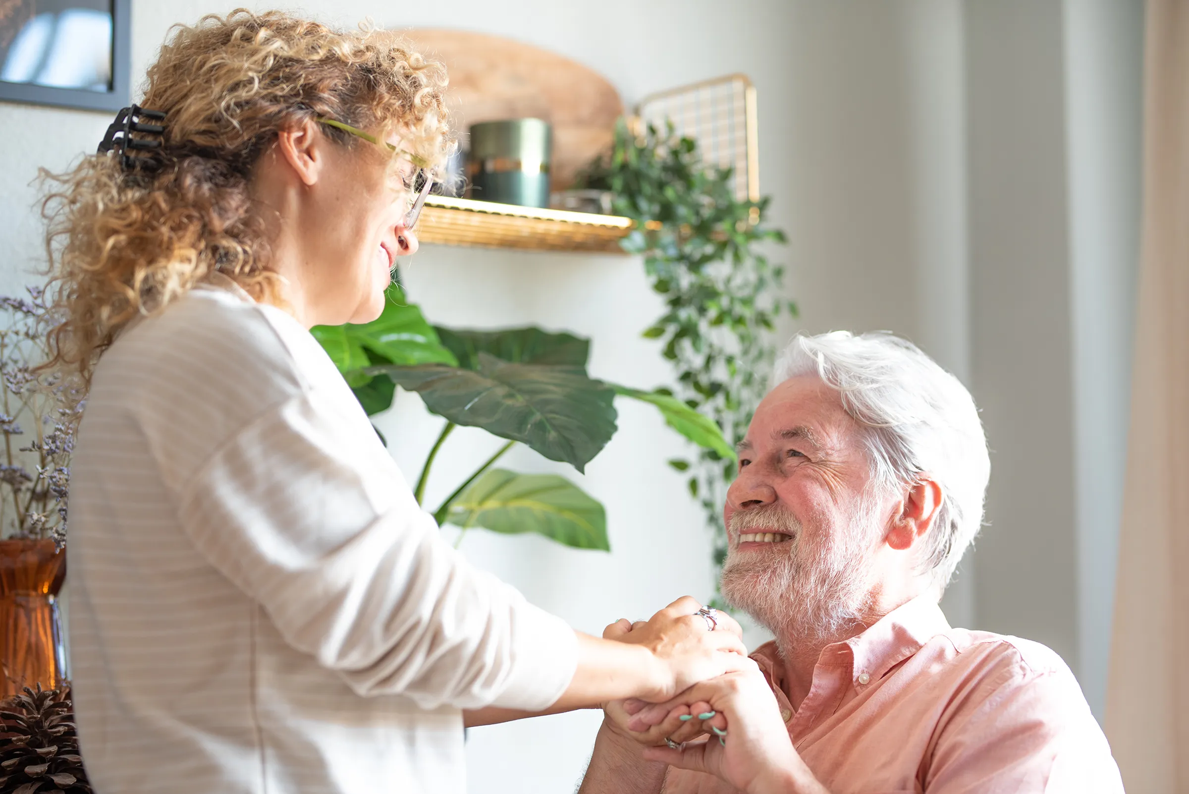 care provider holding hands with man inside florida nursing home