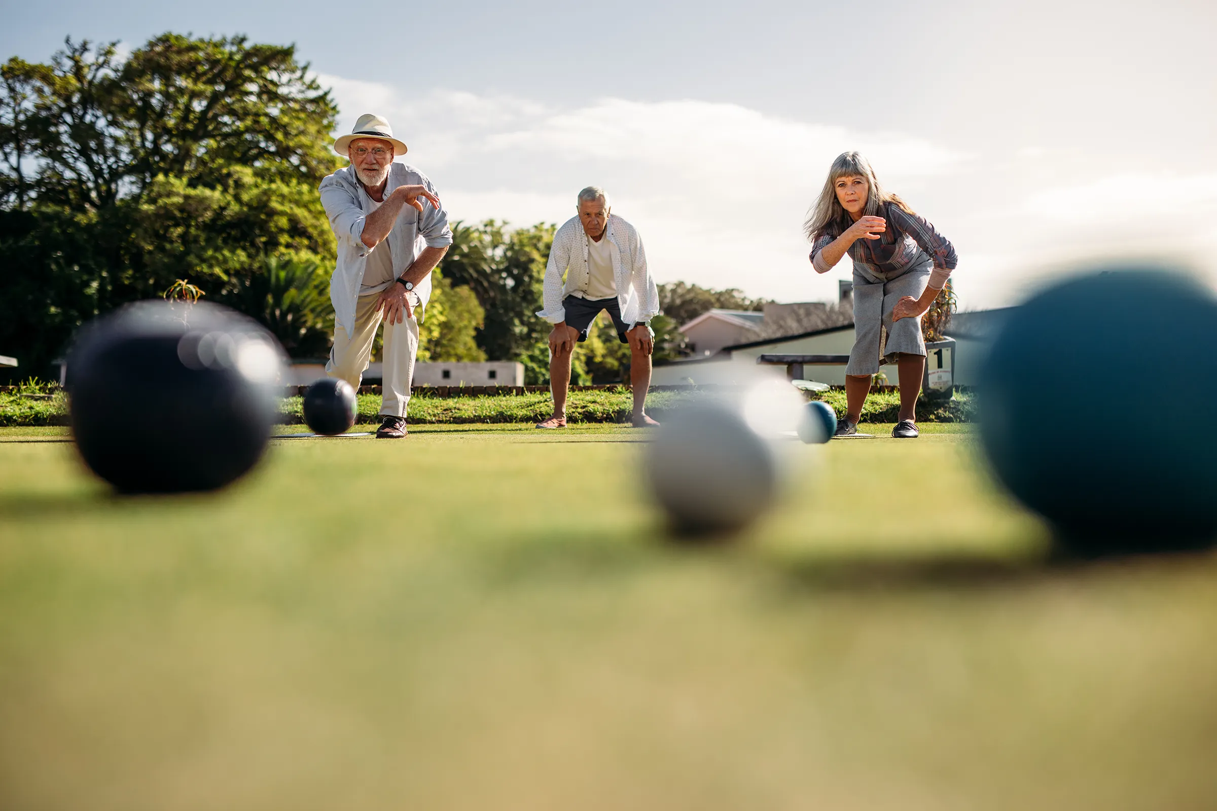 older adults playing bocce ball outside
