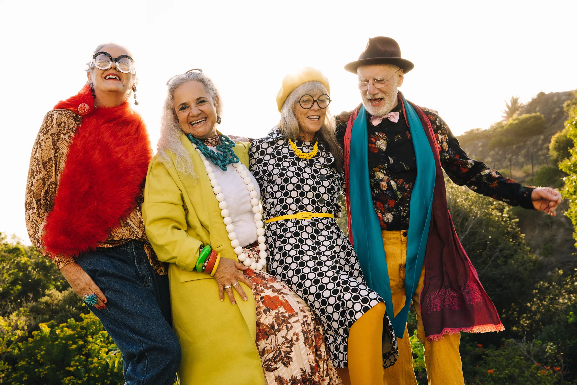 four senior friends dressed in vibrant colors having fun outside