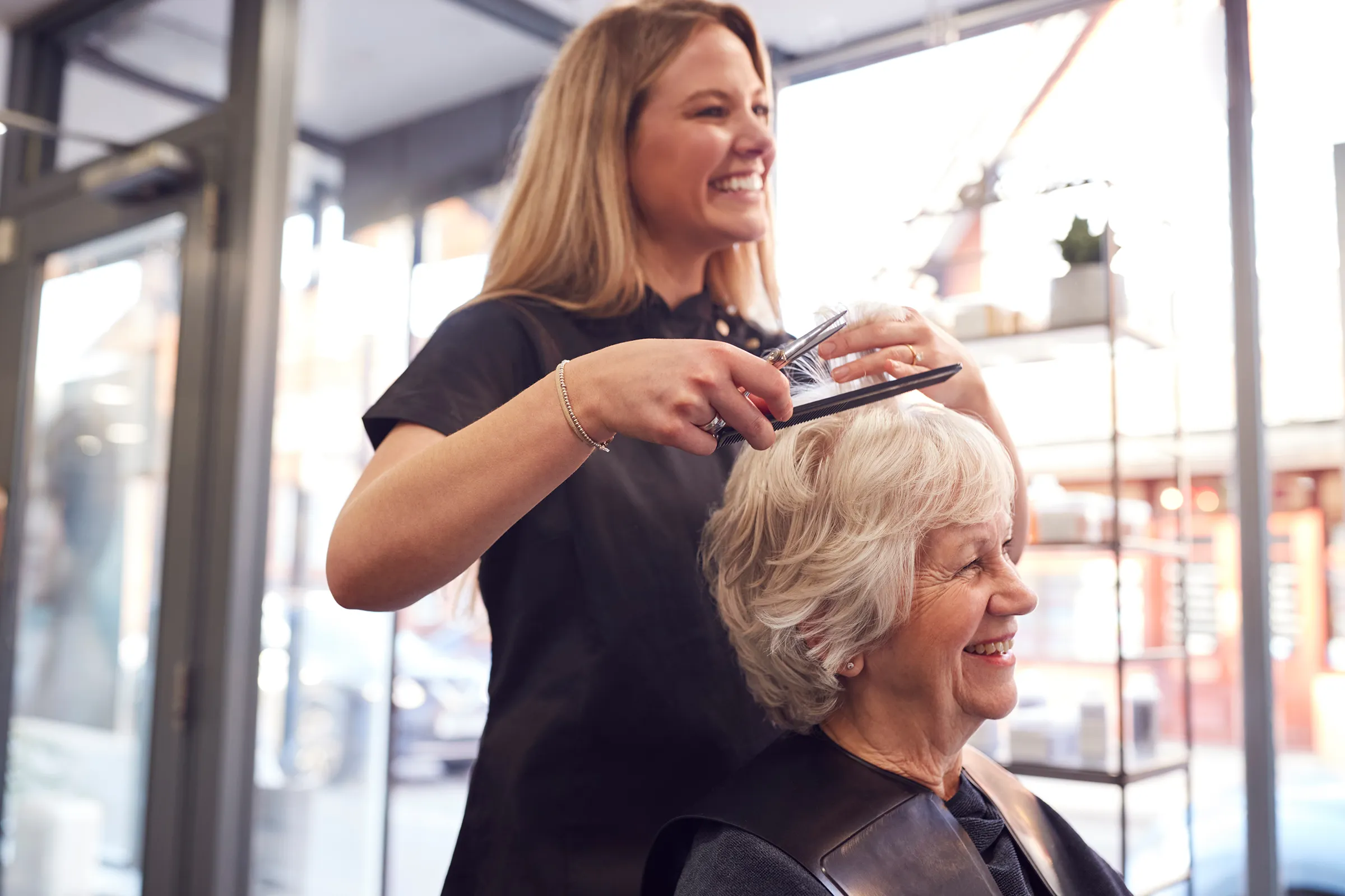 woman getting haircut in salon at senior living facility