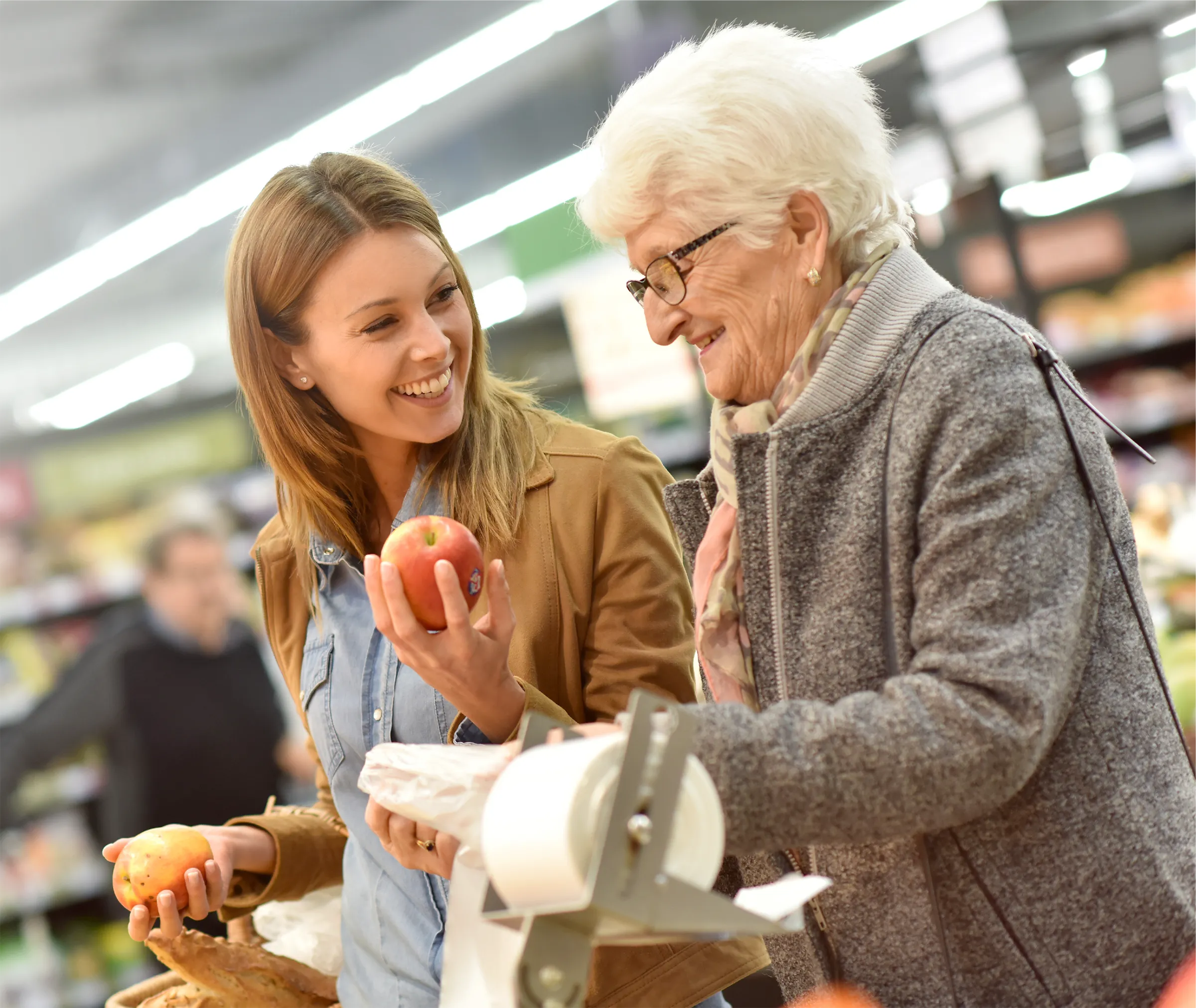 woman assisting senior woman with produce
