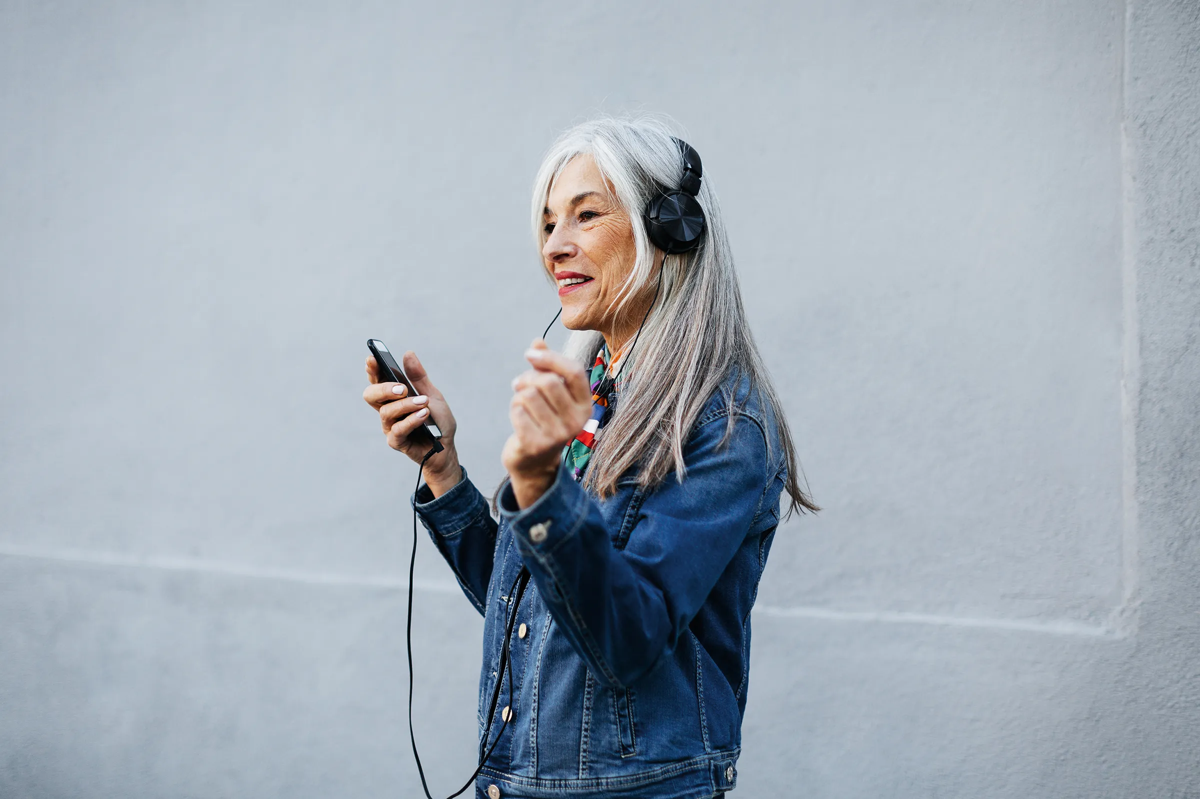 senior woman with headphones enjoying music